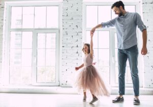 Father spinning daughter and dancing