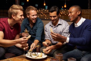 Group Of Male Friends Enjoying Night Out At Rooftop Bar