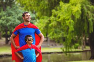 Father and on dressed up as Super hero out with hands on hips.