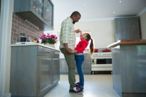 father daughter dancing in kitchen