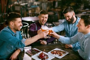 Fathers Drinking Beer In Pub. Friends Toasting With Alcohol Drinks in Bar. 