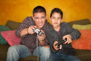 Hispanic father and son playing video games 