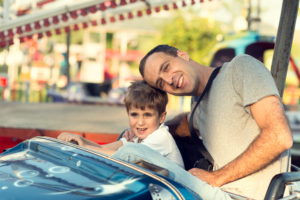 padre e hijo montando en un coche de choque