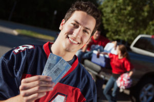 Man showing off football tickets. 